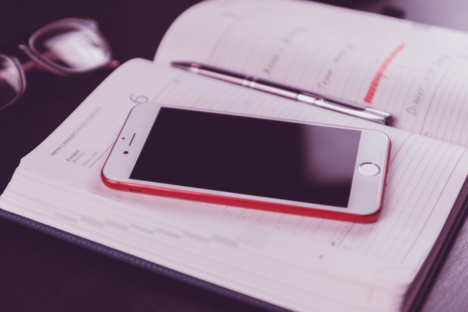 Profissional de salão organizando agenda de clientes em smartphone