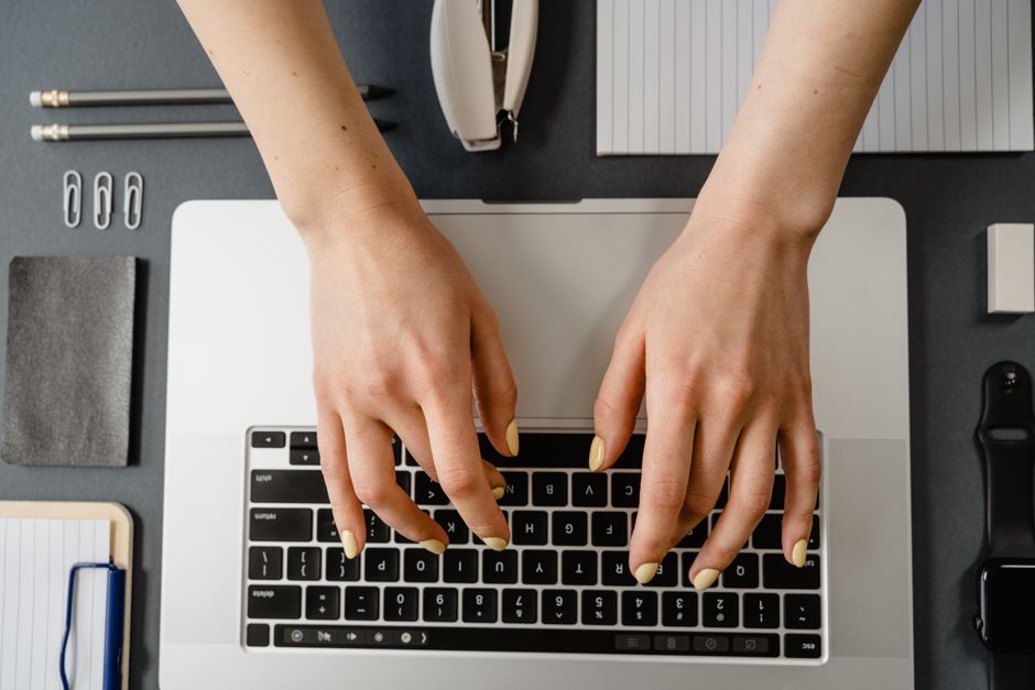 Pessoa digitando repetidamente no computador com expressão de cansaço e frustração