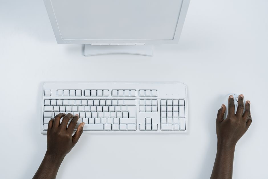 Mãos cansadas digitando repetidamente no teclado do computador diariamente