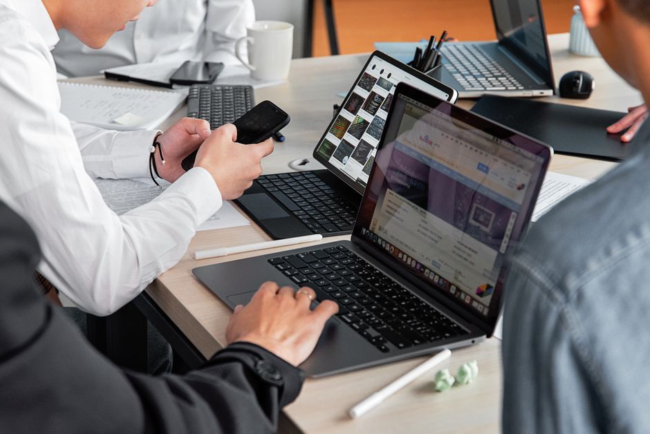Equipe colaborativa usando WhatsApp Business para gerenciar contatos e conversas